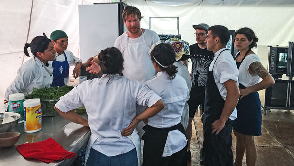 Chefs Esben Holmboe Bang (center, facing camera) of Maaemo in Oslo and Rosio Sanchez (right) of Hija de Sanchez in Copenhagen with the local crew assigned to assist them in assembling and plating 200-plus dishes of their course. Chefs Esben Holmboe Bang (center, facing camera) of Maaemo in Oslo and Rosio Sanchez (right) of Hija de Sanchez in Copenhagen with the local crew assigned to assist them in assembling and plating 200-plus dishes of their course.