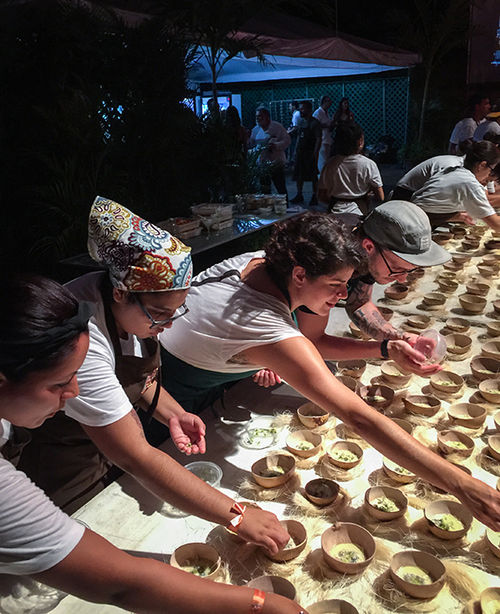 The finishing touch -- an edible flower -- is added to 200-plus bowls of an oyster dish, assembly-line fashion. The finishing touch -- an edible flower -- is added to 200-plus bowls of an oyster dish, assembly-line fashion.