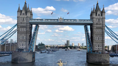 The Silver Cloud is towed aft-first through the iconic Tower Bridge in central London to start its journey to the sea along the Thames River.