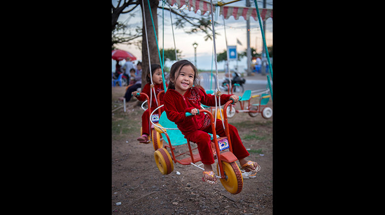 All along the Mekong, the cities and towns in Cambodia and Vietnam recall an ugly past but focus on a promising future. During a sailing aboard Uniworld's River Orchid, Mark Edward Harris caught a glimpse of that future first hand. Pictured here, a child enjoying a ride at a neighborhood amusement park in Kampong Cham, Cambodia.