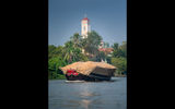 Grain is transported up river in Vietnam past Cai Be's Catholic Cathedral.