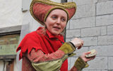 A staffer at Olde Hansa restaurant, in period costume, urging passersby to try the eatery. Olde Hansa, housed in a medieval building, features period menus as well as costumed personnel.