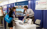 Representatives from Auto France show their product on the trade show floor.
