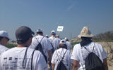 Volunteers in the "Black group" walk behind their group leader, Rick Spencer, before beginning a snow-fence project at Fort Tilden.