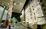 A segment of the slurry wall, part of the World Trade Center's original foundation. At left is the Last Column, a 36-foot-tall piece of welded plate steel removed from the site in May 2002. Recovery workers, first responders, volunteers and victims' relatives signed the column and affixed to it various tributes.