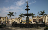The fountain at the center of Lima's Plaza Mayor, with the Presidential Palace in the background at left and the Archbishop's Palace at right.