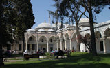 Visitors relax in a courtyard of the former Ottoman sultans' residence, Topkapi Palace. The Pavilion of the Holy Mantle in the background houses relics linked to the Prophet Mohammed and other religious relics.