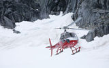 A helicopter lands tourists on an Alaskan glacier.