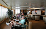 Passengers reading in Seabourn Square during a day at sea.