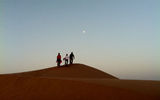 Tourists climb a sand dune before sunrise in the Liwa Desert.