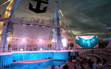 The AquaTheater on the Oasis of the Seas lit up at night.