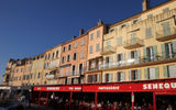 View of the colorfully painted houses that line the Saint-Tropez harbor where yachts moor by the hundreds.