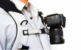 The Capture Camera Clip System enables you to secure your camera to any backpack strap, shoulder strap or belt and release it with the touch of a button. Basically, the device consists of a quick-release plate that screws into the bottom of the camera body and a metal "capture" clip that attaches around a strap or belt. The camera slides out of the clip with the press of a button and slides back in when the camera is no longer in use.