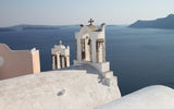 Santorini church bells seen against the backdrop of the deep blue Aegean Sea. Like Mykonos, Santorini counts more than 400 churches.