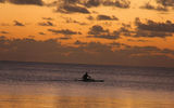 A Rangiroan paddling his outrigger canoe at dusk.