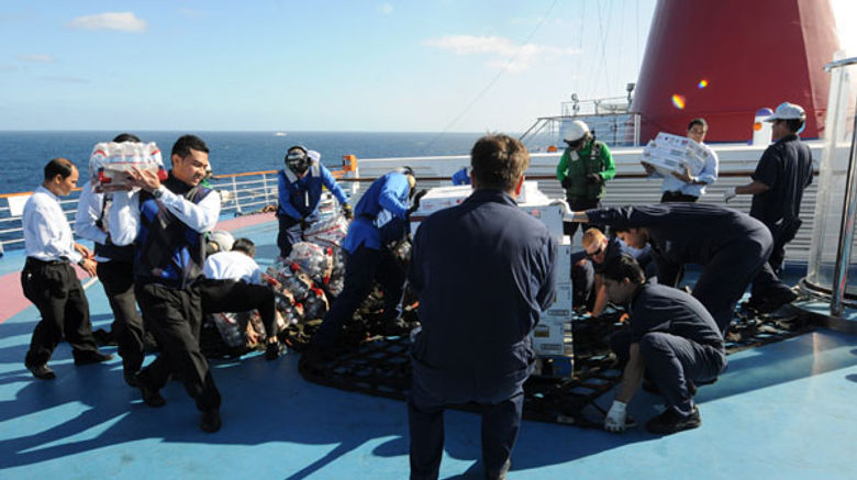 Sailors from the aircraft carrier Ronald Reagan helped Carnival Splendor crew unload food and water supplies from the Navy vessel.