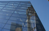 A reflection of 1 WTC in the 9/11 Memorial Museum, which sits at the center of the plaza.