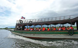 Ama Waterways passengers ride motorboats across Tonle Sap Lake to board the AmaLotus for the inaugural downstream sailing