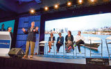 My Best Business Decision panel, from left: Joanie Ogg, at podium, and Scott Koepf of Avoya, standing. Seated: Meredith Hill of Gifted Travel Network, Jackie Friedman of Nexion, Debbie Fiorino of CruiseOne and Cruises Inc., and Vicky Garcia of Cruise Planners