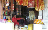 A vendor outside the Sri Lakshmi Narayan Mandir, a major New Delhi temple, sells religious articles and offerings, such as marigold garlands and sweets, used in Hindu puja, or worship.
