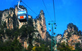 Visitors begin their trip up to the Yuanjiajie Scenic Area's viewing locations, connected by a series of paved hiking pathways and brief bus rides, onboard a relatively short but photogenic cable car ride up to Tianzi Mountain.