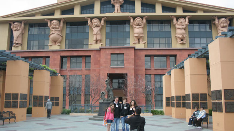 Taking an official tour of one's native stomping grounds is bound to be enlightening. When that home turf happens to be the adopted town of Walt Disney, and the tour is hosted by Adventures by Disney (ABD), things could have gone several ways. Pictured here, a family on the ABD tour poses in front of the Michael D. Eisner building, aka "the Seven Dwarfs building," at Walt Disney Studios. Photos by Michelle Baran; posted March 8, 2012