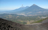 Volcan de Fuego, seen erupting, and the dormant Volcan de Agua, as seen from the slopes of the also-active Volcan de Pacaya.