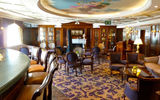 Located at the entrance to the dining room, the Discoveries Bar exemplifies the ship's Edwardian decor with its dark paneling, ornate molding and ceiling fresco.