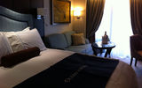 Concierge staterooms on Deck 9 feature dark wood paneling, a veranda, ample closet space, a work desk and a couch.