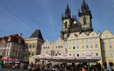 Prague's Old Town Square with the iconic Tyn Church in the background and some of the square's many cafes in the foreground.