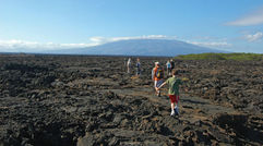 Guests on the yacht La Pinta traverse the rugged landscape of Isabella Island, the largest of the Galapagos. Five of its six volcanoes are active.