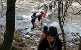 Templestay participants and guides navigate a stream on a meditative nature walk near Woljeongsa Temple.