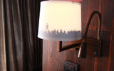 An audience in silhouette on a nightstand lampshade.