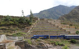 A train carrying passengers en route to Machu Picchu passes restored Inca terraces and a restored Inca bridge outside Ollantaytambo in the Sacred Valley.