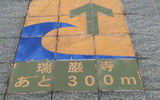 A sign on a sidewalk in the tourist village of Matsushima points the way to safety should a tsunami alert be sounded. The town draws mostly domestic tourists to see its island-filled bay. The islands served to reduce the impact of the wave on Matsushima, which ended up with relatively minor flooding. Photo by Arnie Weissmann