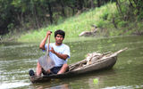 A fisherman paddles upstream on a tributary of the Amazon.