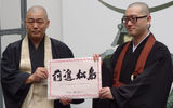 Two Buddhist monks at the Zuiganji Temple in Matsushima, a coastal city south of Sendai severely damaged by the tsunami, hold a sign that says, "Go forward Matsushima."