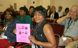 Kimberly Fountain, travel counselor, Splendid Destinations Travel, Sugar Land, Texas, showing off a coupon that entitles her to collect her prize of business books meant to assist home-based agents.