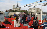 Tourists take in the view of Notre Dame cathedral from the Seine aboard a riverboat operated by Bateaux Parisiens.
