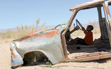 A local child plays among abandoned cars collected by a former Solitaire, Namibia, businessman.