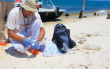 A government contractor checks the beaches of Dauphin Island, Ala., for tar balls.