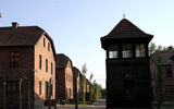 Barracks at the Auschwitz concentration camp outside of Krakow look innocuous here, but the guard tower and barbed wire in the foreground tell another story.