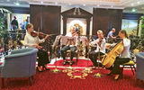 A string quartet plays for embarking passengers.