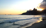 A surfer takes on the waves on Ipanema Beach.