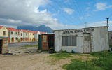 Many local shanties, constructed out of corrugated steel like the church above, are being torn down and replaced with new housing like that shown across the road.