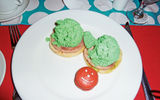 These unnaturally green scrambled eggs are served atop normal pink Canadian bacon and an English muffin half.
