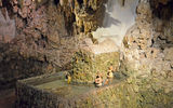 This hidden grotto area features a cave-like design with sculpted stalactites hanging from the ceiling and a fountain of rotating carved figures powered by water pressure.