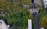 At the base of the Hohensalzburg Fortress cliff, the tracks of the funicular railway await to take the group up to the fortress perched above.