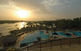 The sun begins to set over the Nile (and swimming pool), seen from the deck of Chobe Safari Lodge in Murchison Falls National Park.