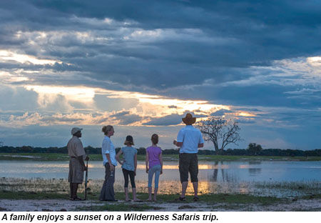 A family enjoys a sunset on a Wilderness Safaris trip.